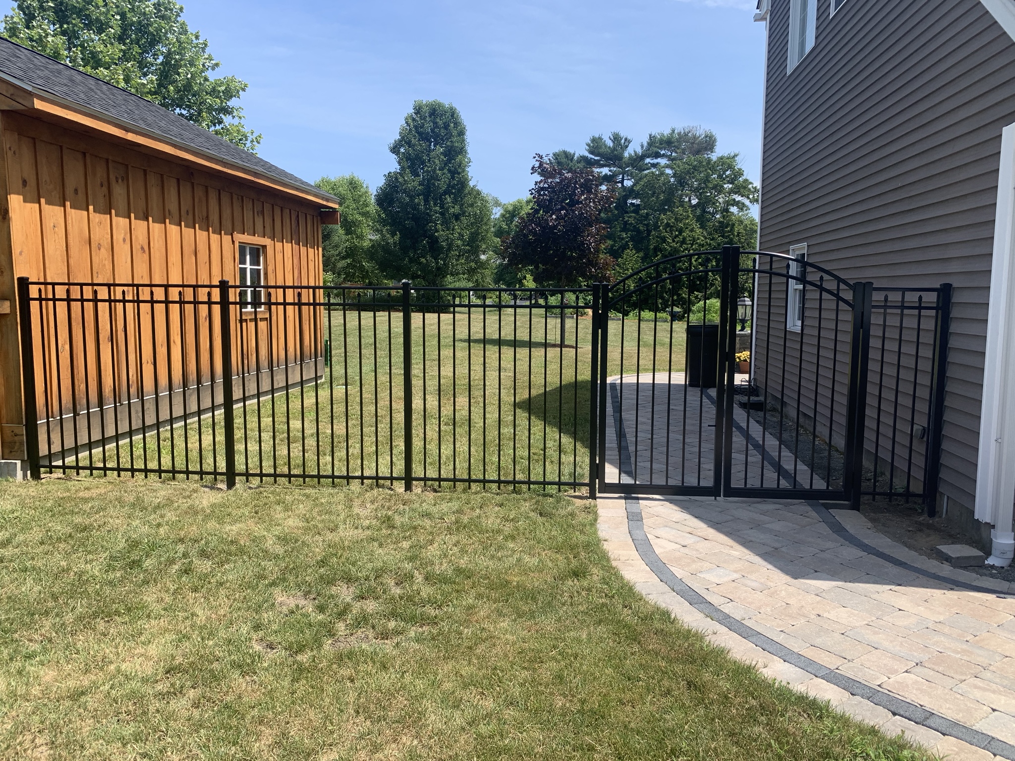 Black ornamental aluminum fence with arched gate installed in Rhode Island by Lynch Fence