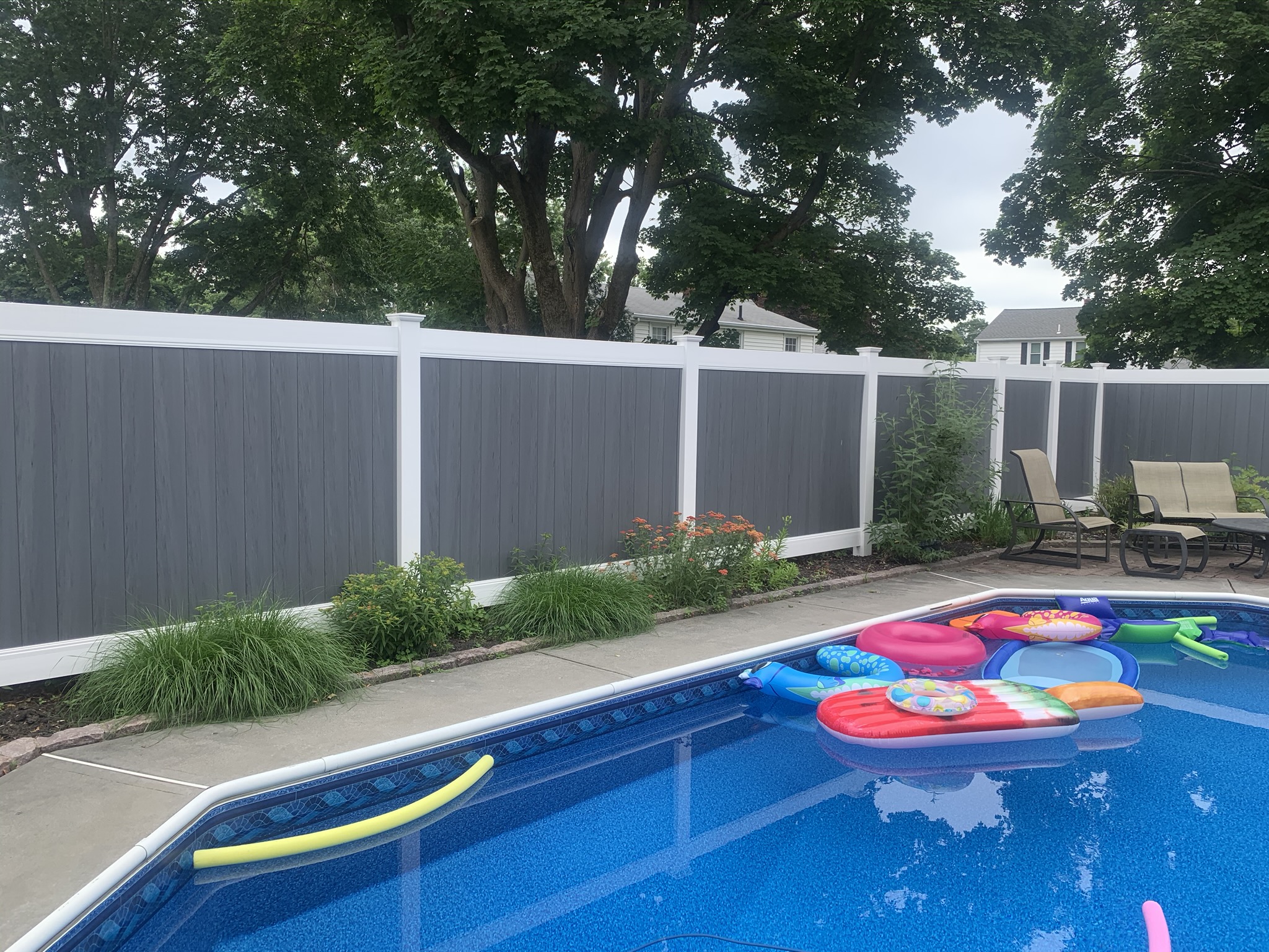 Two-tone gray and white vinyl pool privacy fence installed in Rhode Island